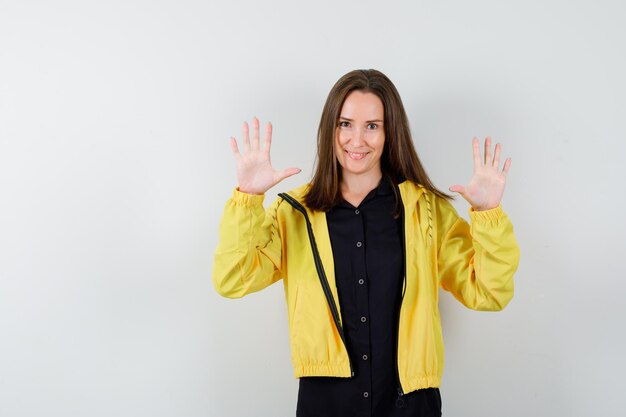 Young woman raising palms in surrender gesture