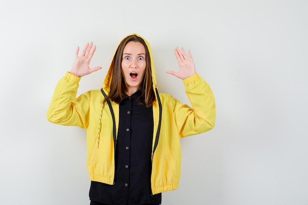 Foto gratuita giovane donna alzando le mani in gesto di resa