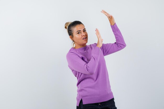 Young woman raising palms in surrender gesture