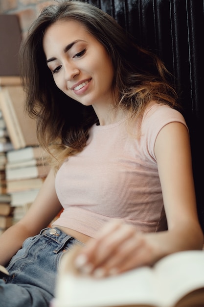 Free photo young woman reading a book at home