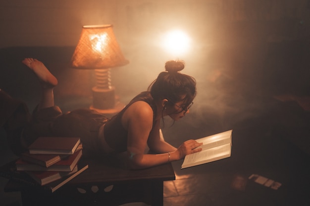 Free photo young woman reading a book at home