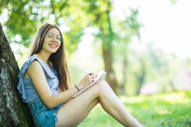 公園で本を読んでいる若い女性