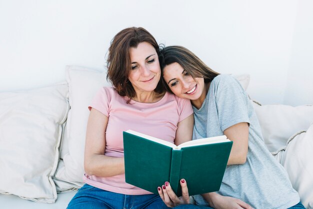 Young woman reading book with woman