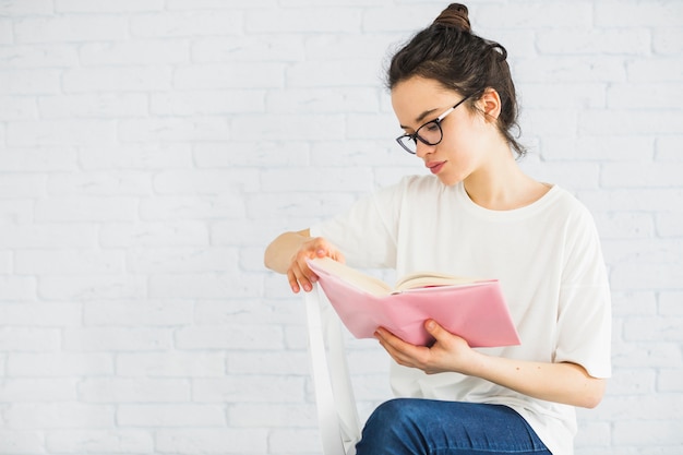 Young woman reading on chair