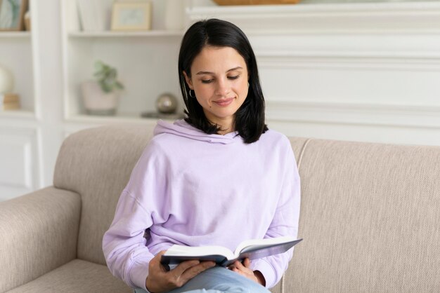 Young woman reading from a book at home