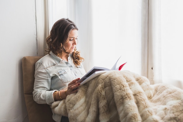 Foto gratuita giovane donna che legge una rivista