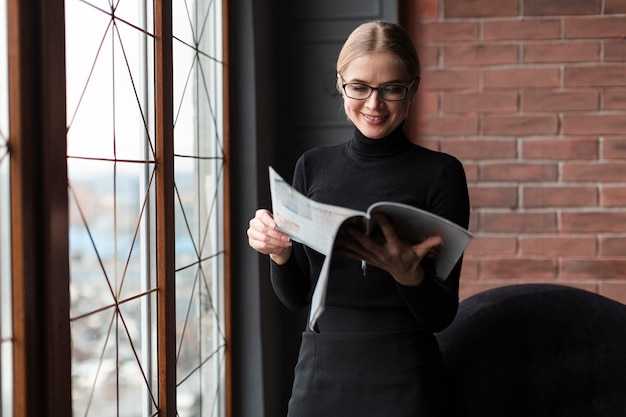 Free photo young woman reading magazine