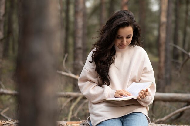 Молодая женщина, чтение в природе