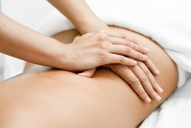 Young woman receiving a back massage in a spa center.