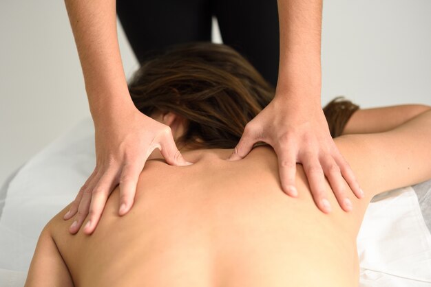 Young woman receiving a back massage in a spa center.