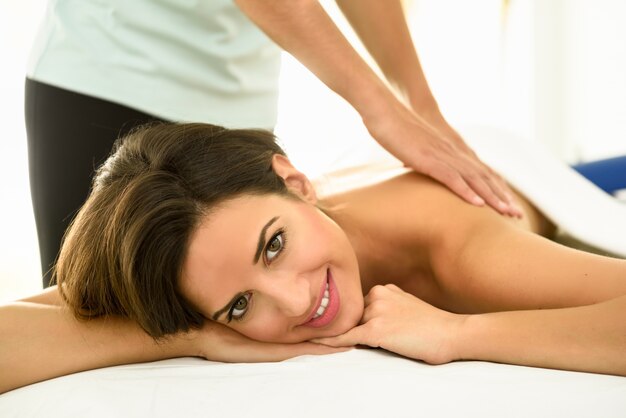 Young woman receiving a back massage in a spa center.