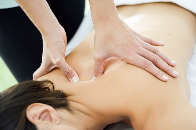 Young woman receiving a back massage in a spa center.