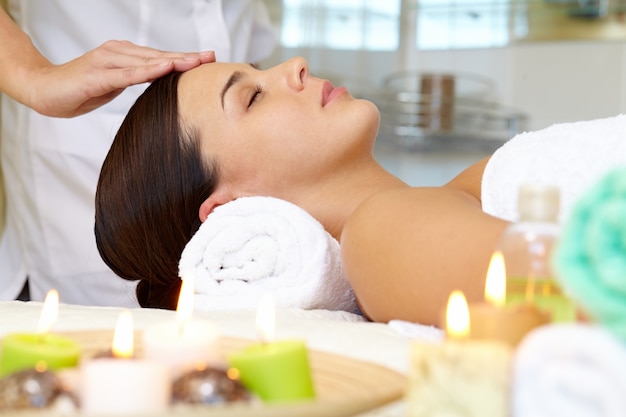 Free photo young woman receiving facial massage