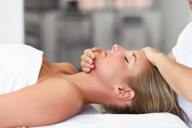 Young woman receiving a head massage in a spa center.