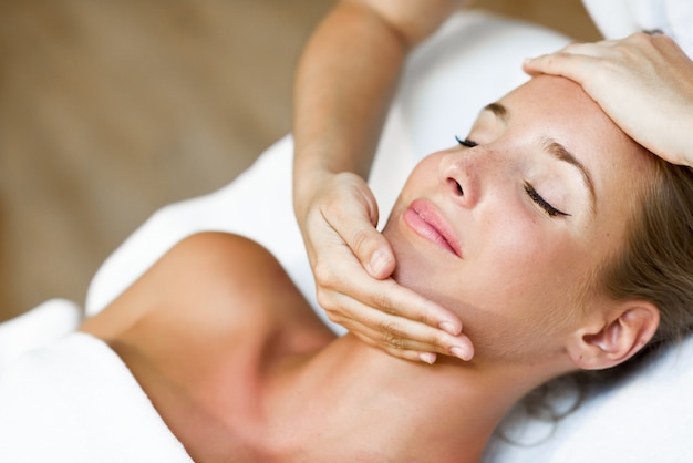 Young woman receiving a head massage in a spa center.