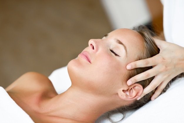 Young woman receiving a head massage in a spa center.