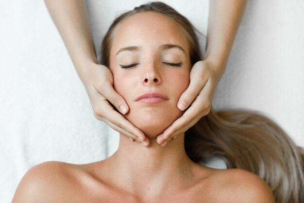 Young woman receiving a head massage in a spa center.