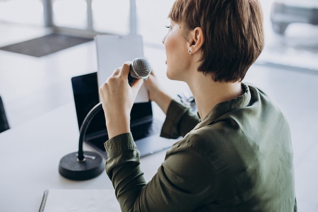 スタジオで演技する声を録音する若い女性