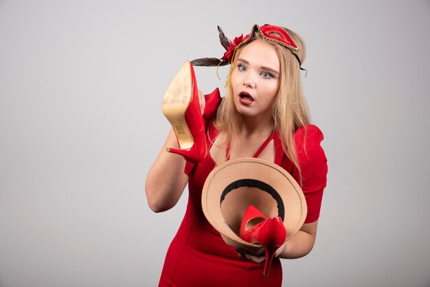 Young woman in red dress looking at heels. 