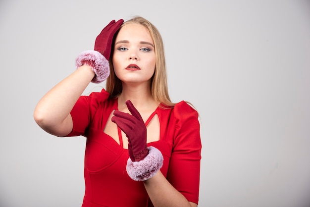 Young woman in red dress posing to camera. 