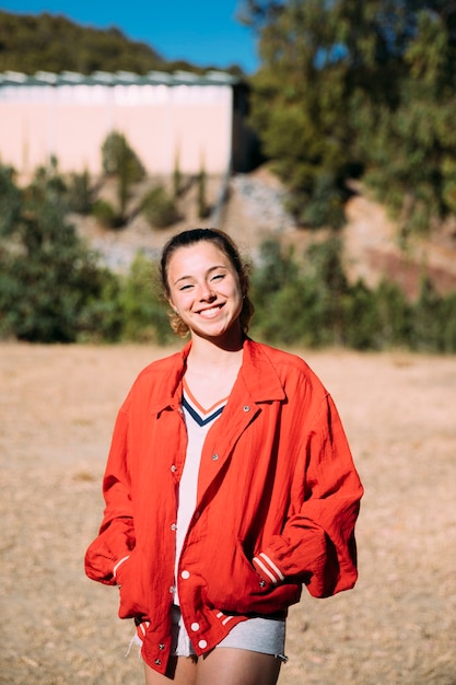 Young woman in red jacket looking at camera