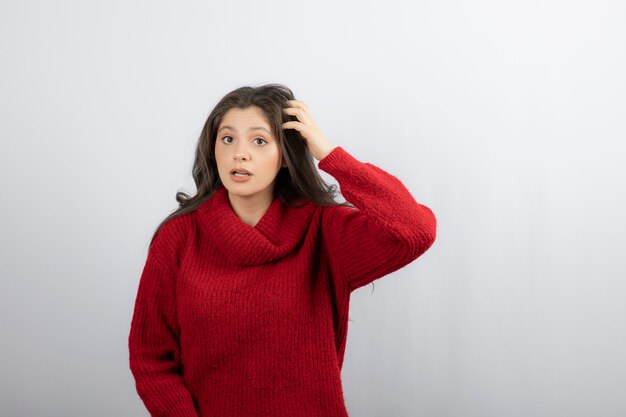 Young woman in red warm holding head