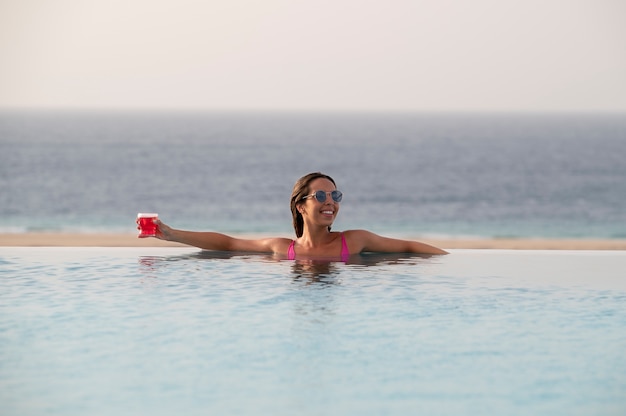 Foto gratuita giovane donna che si rilassa da sola in piscina