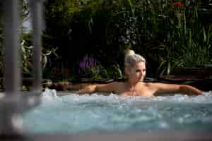 Free photo young woman relaxing in a jacuzzi