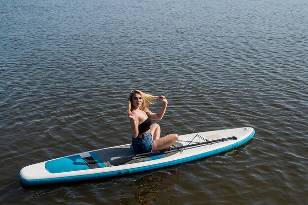 暑い​夏​の​日に​sup​ボード​で​横​に​なって​リラックスして​若い​女性