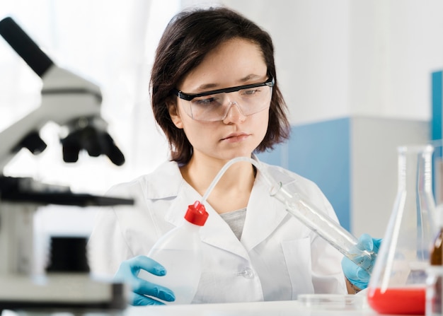 Free photo young woman researcher with protection glasses