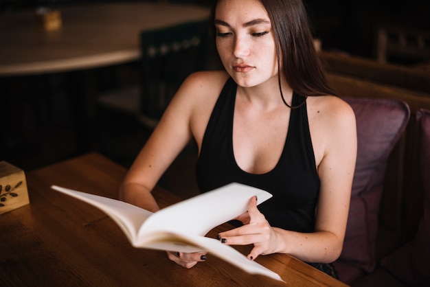 A young woman in a restaurant with the menu in hands