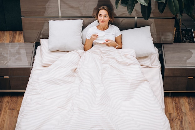 Free photo young woman resting in bed in the morning