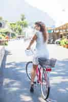 Free photo young woman riding bicycle