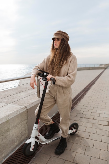 Foto gratuita giovane donna in sella a uno scooter elettrico