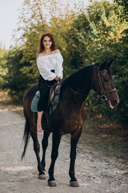 森の中で馬に乗る若い女性