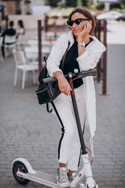 Young woman riding scooter in the street