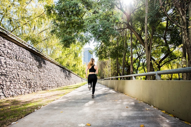 Foto gratuita giovane donna che corre all'aperto con abiti sportivi