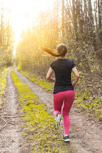 Young woman running through the forest