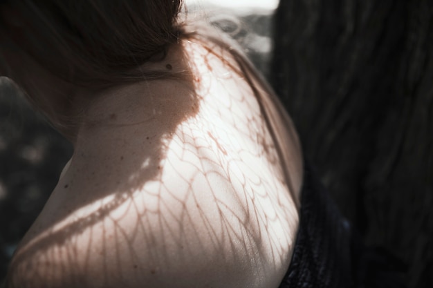 Young woman's shoulders in forest