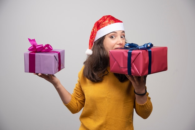 クリスマスプレゼントとサンタクロースの赤い帽子の若い女性。