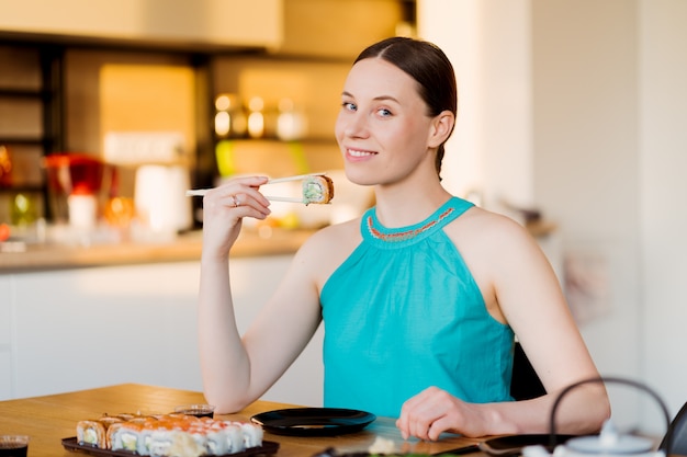 若い女性が彼女の寿司を味わう