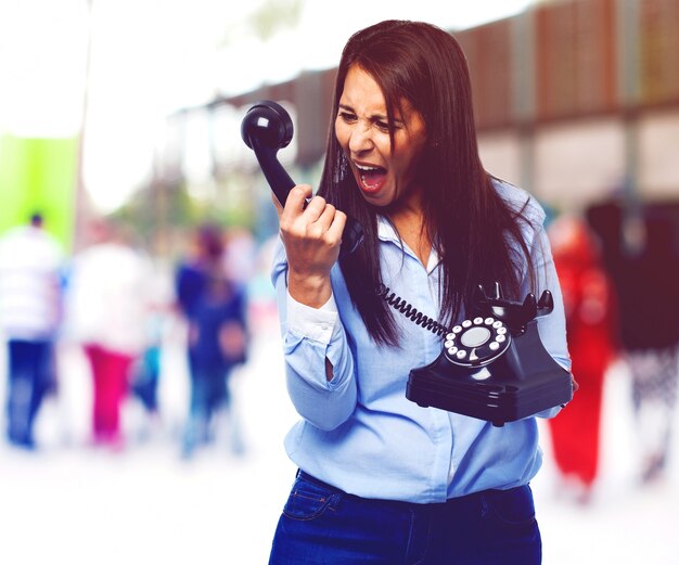 Young woman screaming to the telephone