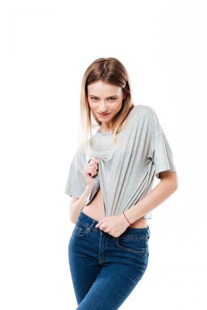 Young woman seductively looking and lifting shirt