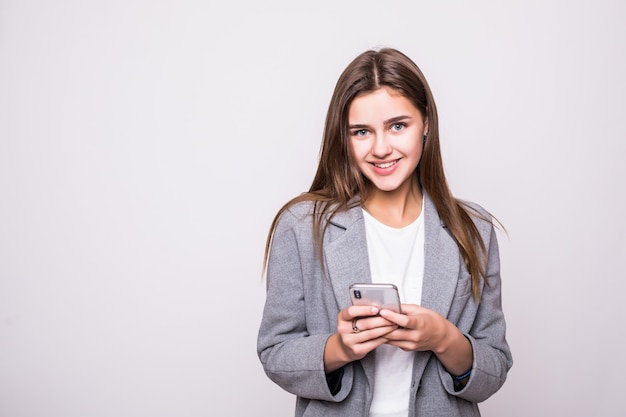 Young woman sending a sms on cell phone, isolated on white background