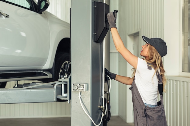 Young woman service employee lifting car