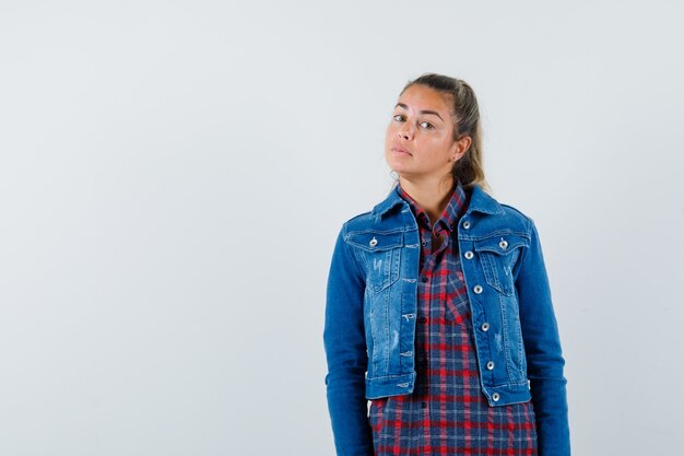 Young woman in shirt, jacket looking at camera and looking sensible, front view.