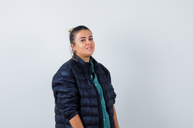 Young woman in shirt, puffer jacket and looking confident. front view.