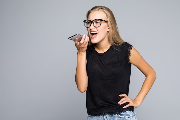Young woman in shirt screaming on phone isolated gray background