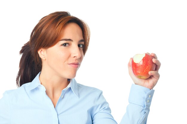 Молодая женщина, показывая кусает красное яблоко
