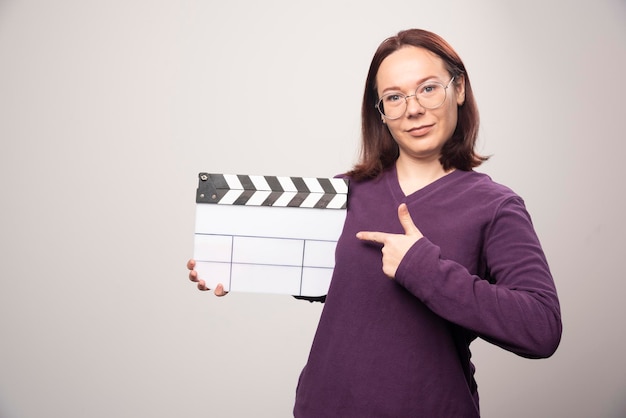 Foto gratuita giovane donna che mostra un nastro cinematografico su un bianco. foto di alta qualità